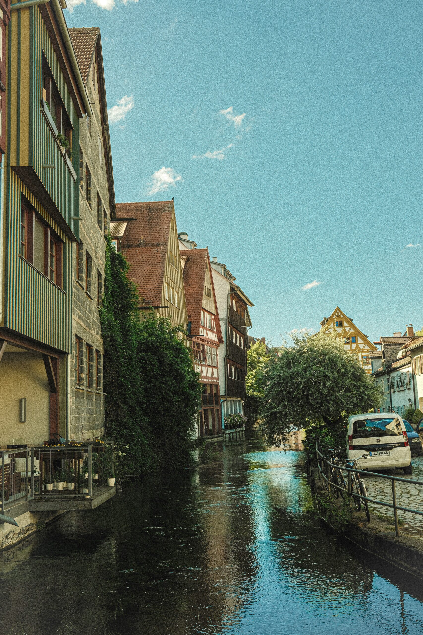 Altstadt mit Fachwerkhäusern entlang eines Kanals bei klarem Himmel.